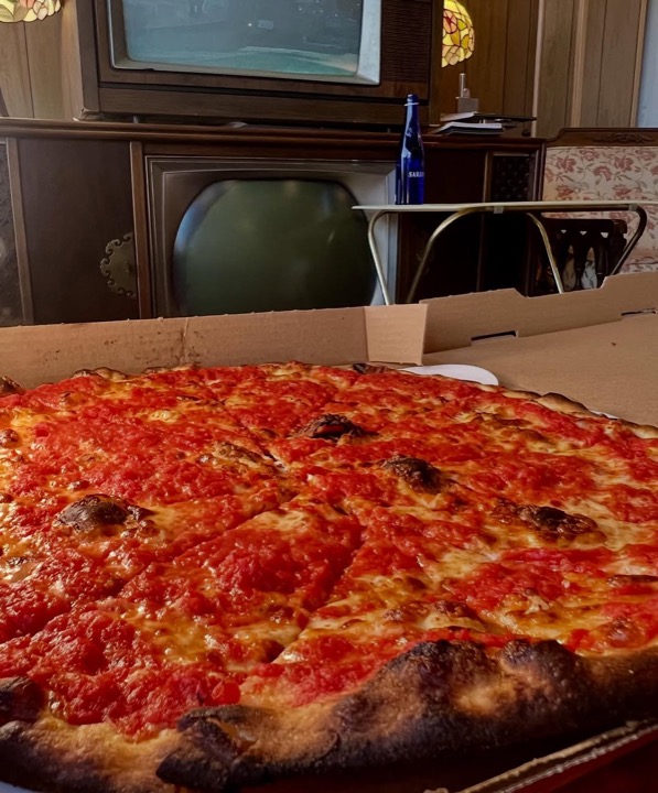 Trenton Style Tomato Pie — mozzarella underneath, bright crushed-tomato sauce on top, pecorino flakes, EVOO drizzle, charred crust edge.