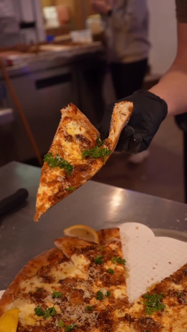 White Garlic pie — no tomato, dollops of ricotta, melted mozzarella, roasted garlic cloves, finished with fresh herbs and EVOO drizzle.