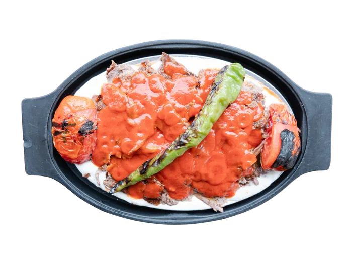 Iskender kebab with sliced gyro meat over pita, tomato sauce and yogurt